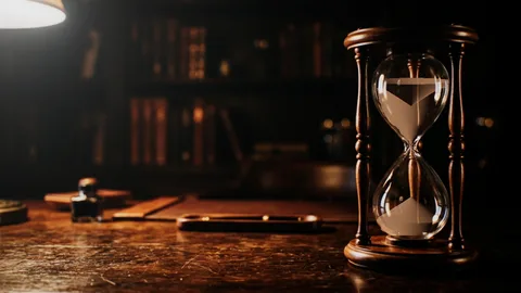 Hourglass : an hourglass on a desk in the dark